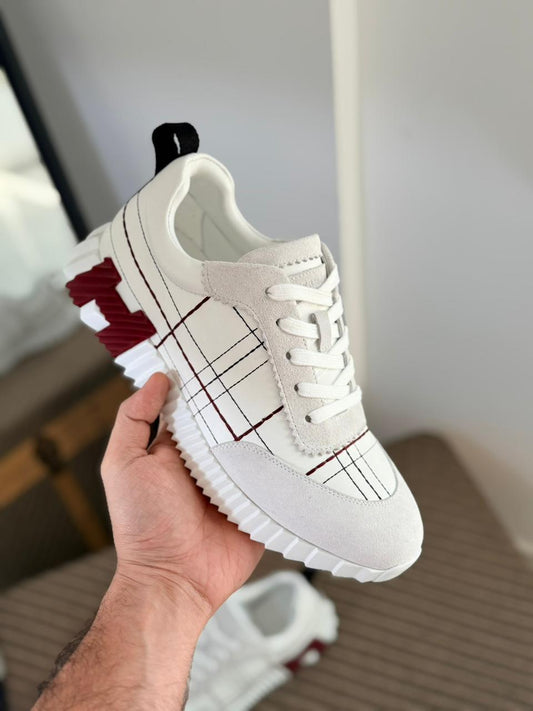 Hermès Bouncing sneakers are crafted from calfskin and suede goatskin, featuring a tartan-inspired motif