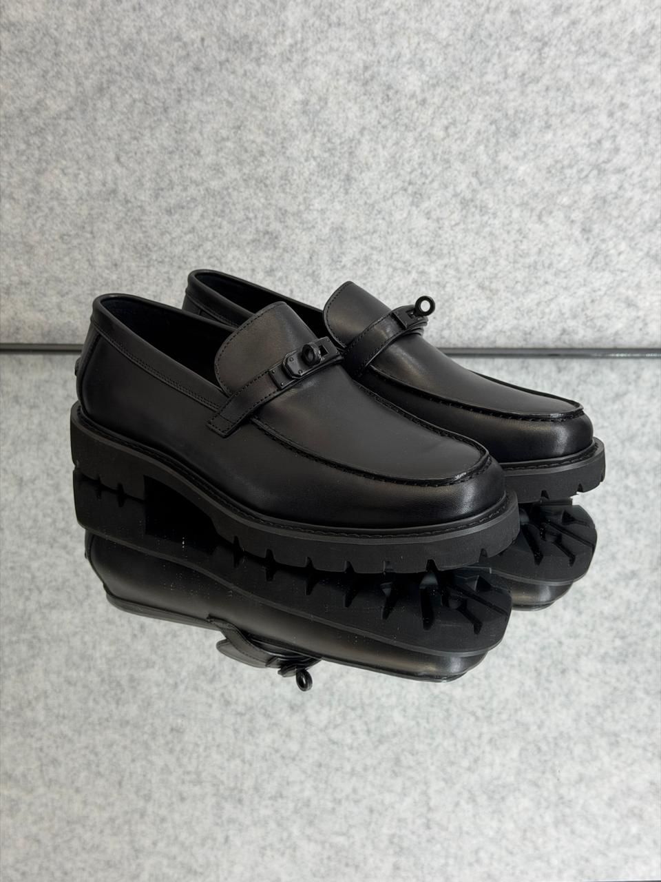 Hermès Icone loafer in black calfskin leather featuring a Kelly buckle and a light notched sole.