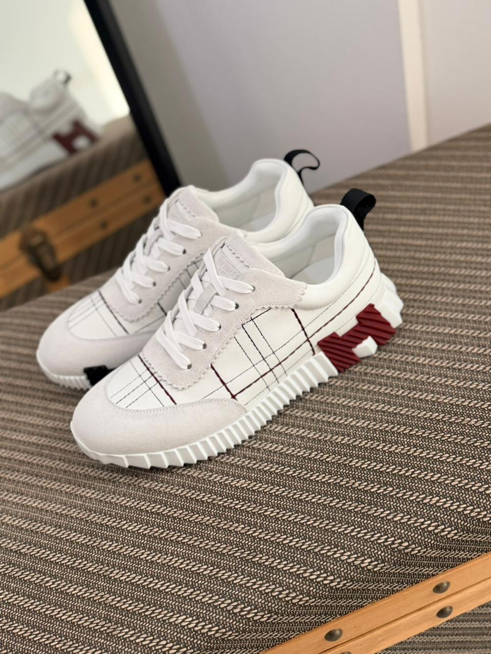 Hermès Bouncing sneakers are crafted from calfskin and suede goatskin, featuring a tartan-inspired motif