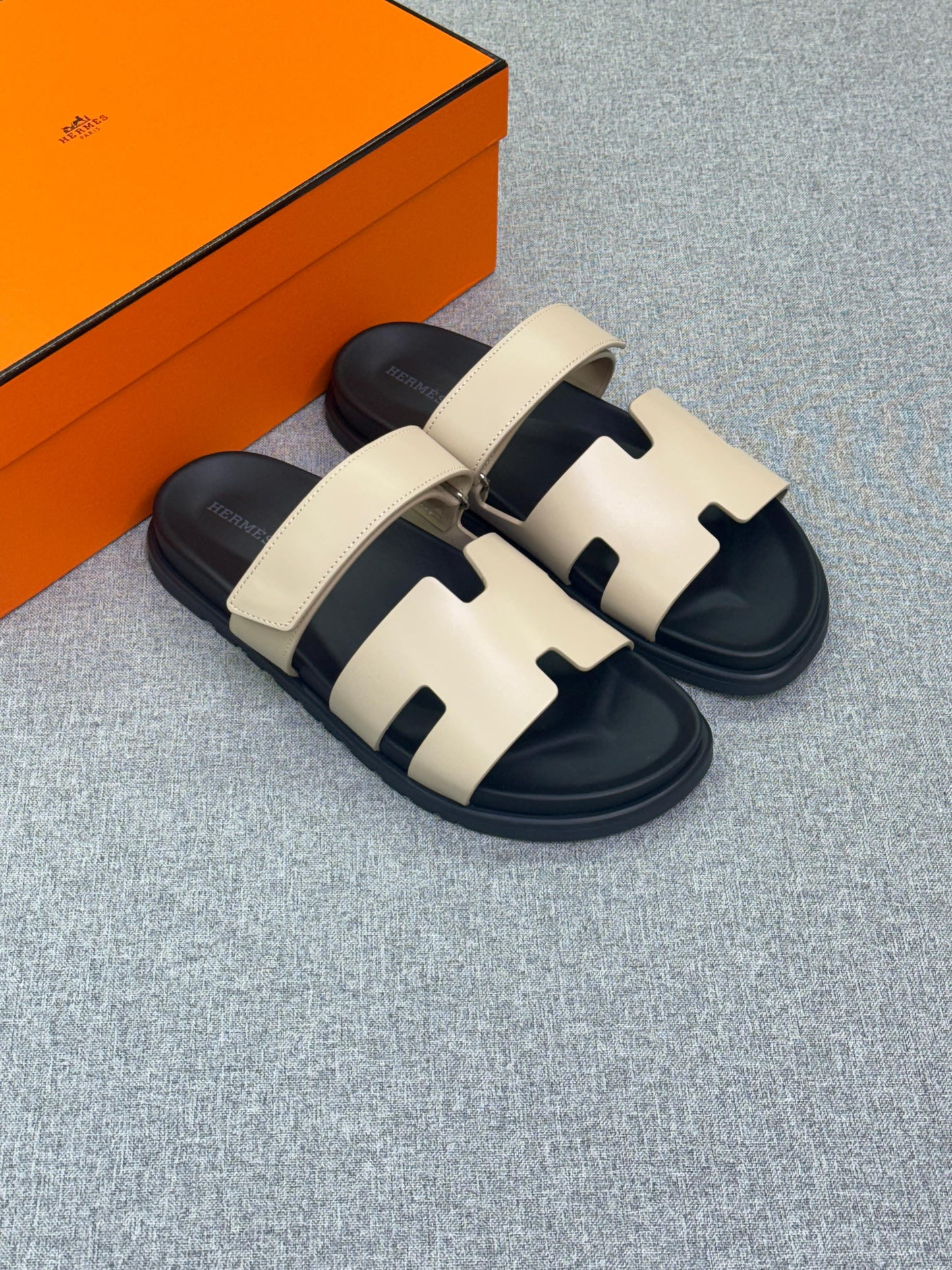 Hermès Chypre sandal in Beige Argile calfskin leather with a black anatomic rubber sole.