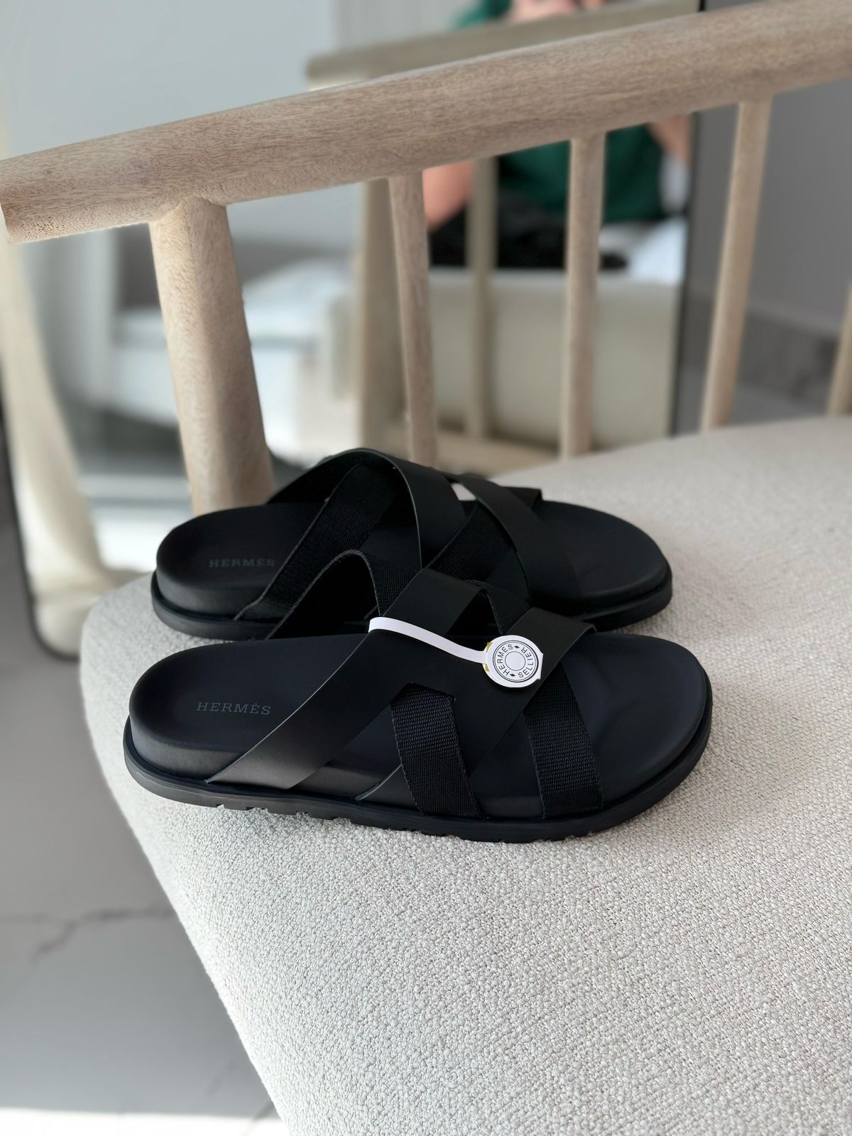 Hermès Kazimir sandal, crafted from black leather and fabric straps featuring an interlaced "H" silhouette.